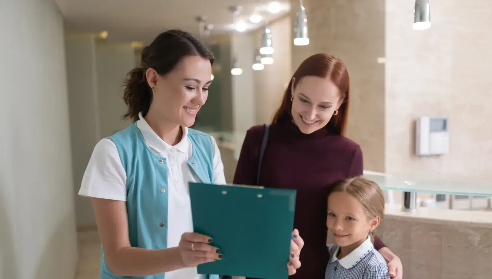A child arriving at the front desk for a first visit