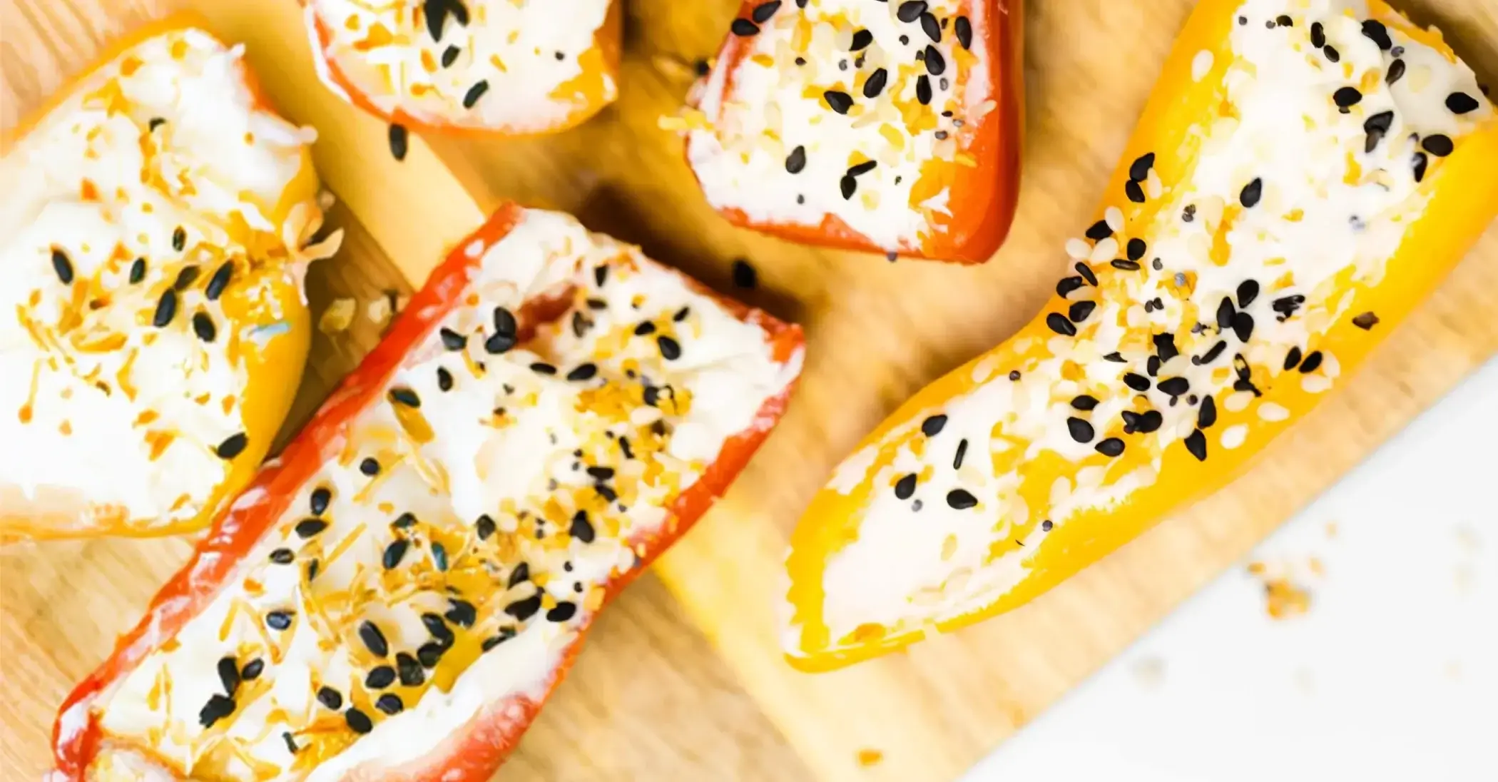 A bell pepper strip topped with cream cheese and everything bagel seasoning